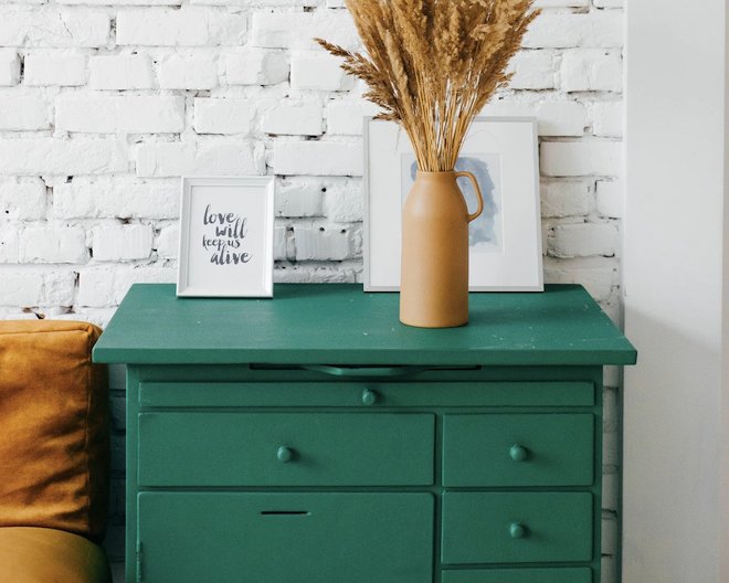 An image of a chest of drawers with a plant on top